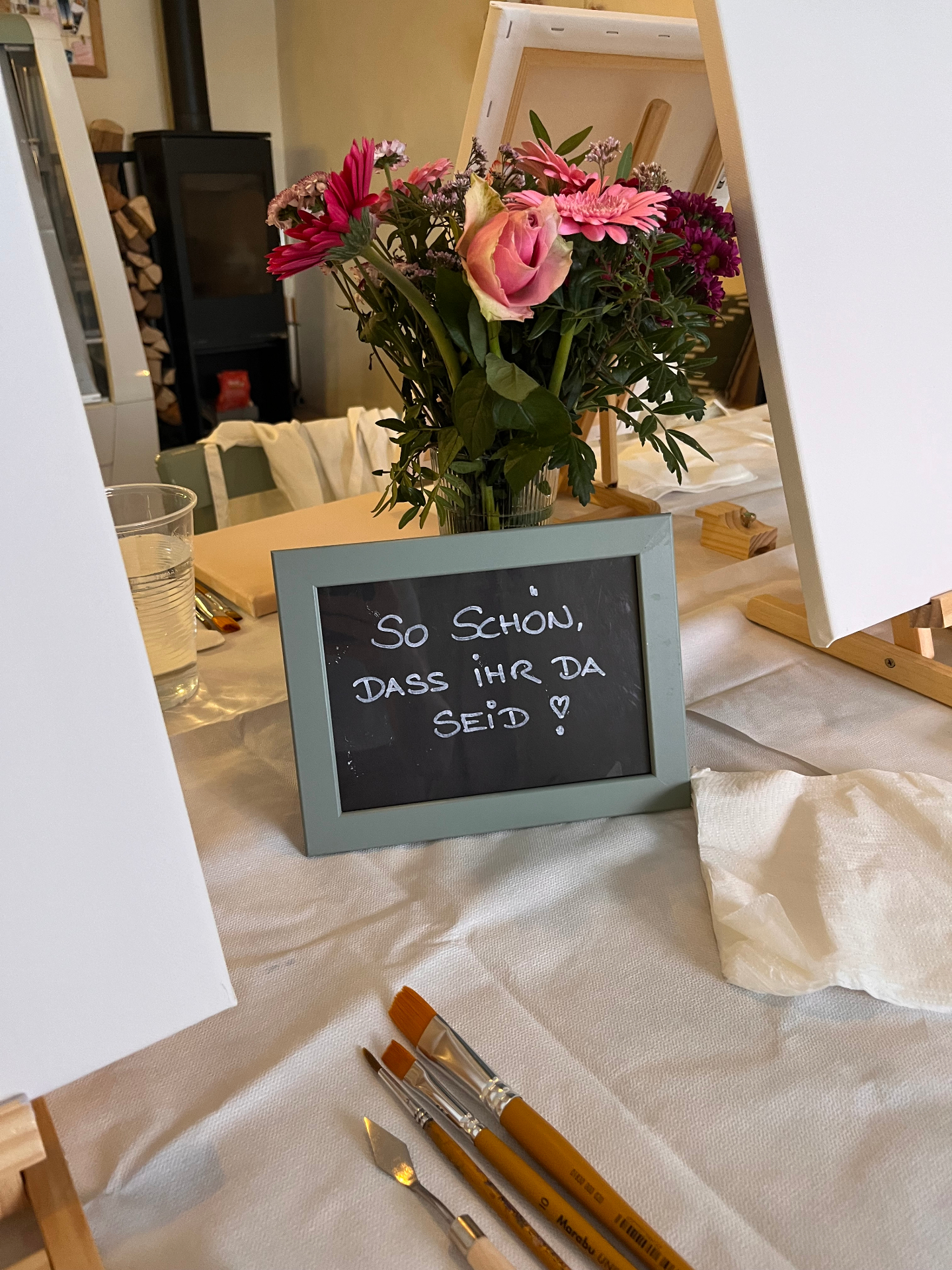 Liebevoll gedeckter Tisch mit Blumen und Pinseln